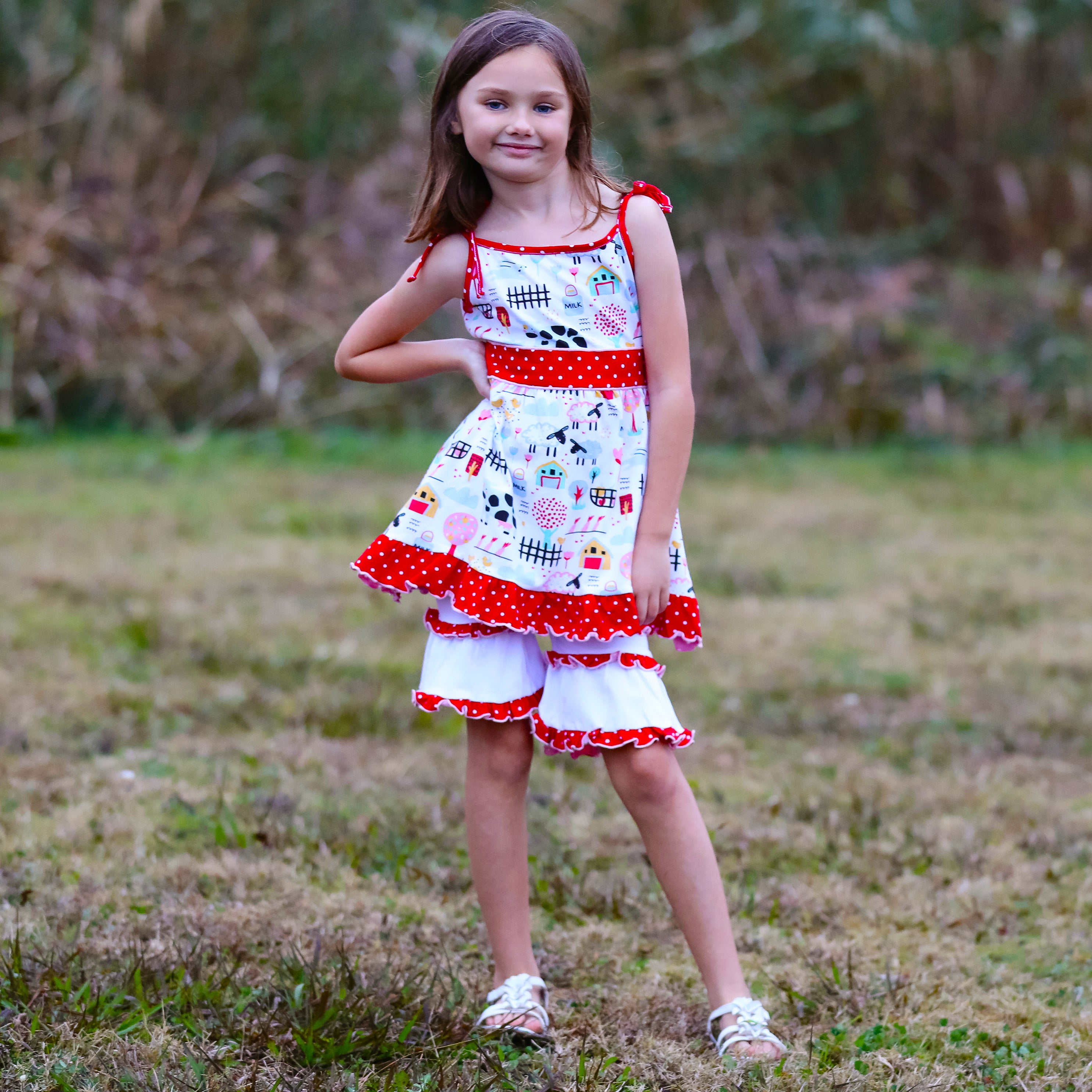 AnnLoren Little & Big Girls Farm Animals Dress with Capri Ruffle featuring farm animal print and pink-red polka dot sash.